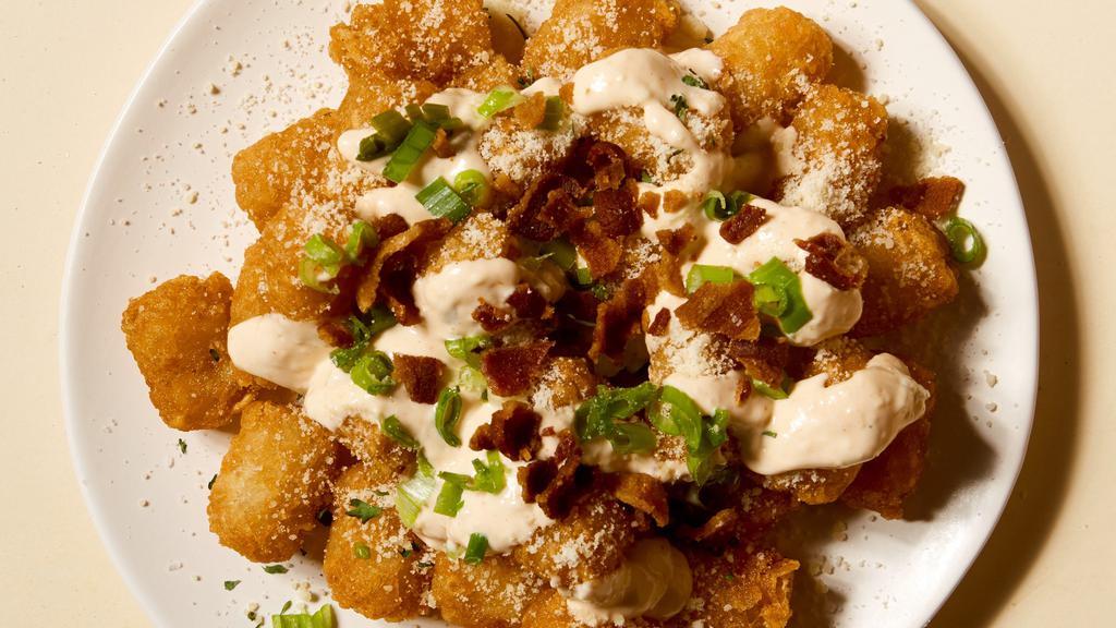Loaded Bacon Tots · Tater tots with cheddar, dirty truffle sauce and bacon crumble