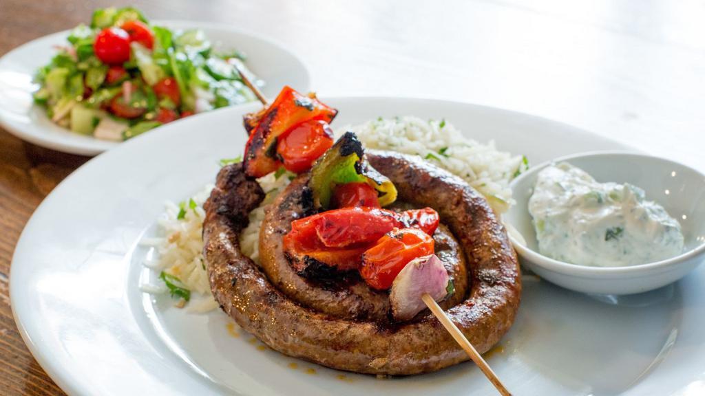 Merguez Grill · house-made spicy lamb & beef sausage, served over herbed rice, grilled vegetable skewer, pickled red cabbage & cucumber yogurt