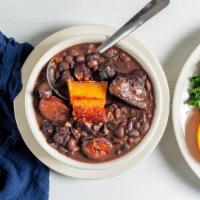 Black Beans Stew / Feijoada · Slow cooked black bean stew, dried meat, bacon, pork shoulder, sausage. Served with rice, co...