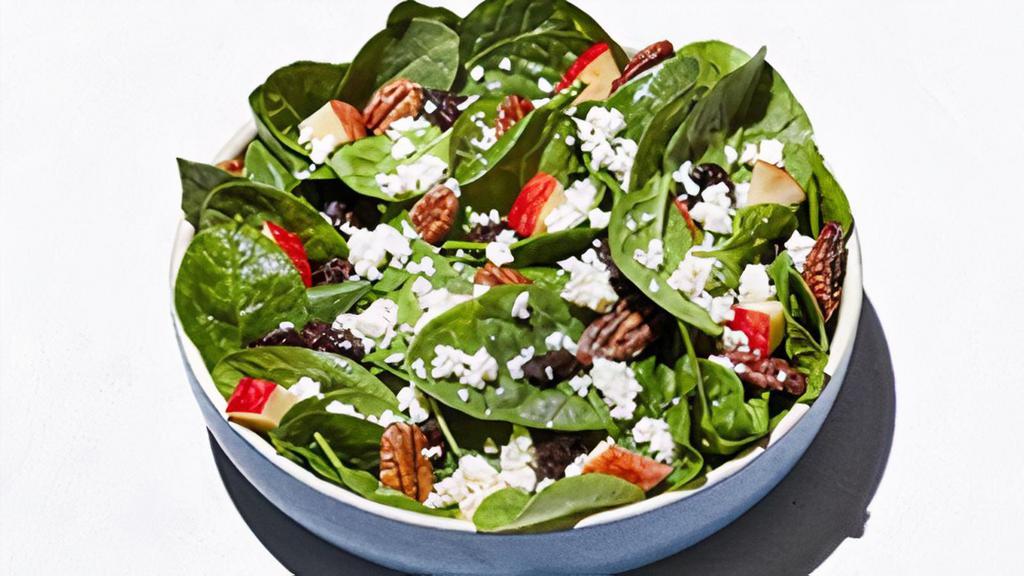 Enlightened Spinach Salad · Fresh spinach, dried cherries, diced apples, house-made glazed pecans and authentic sheep’s milk feta cheese.