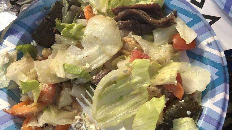 Greek Salad · Spring Mix, Spinach, Tomatoes, Cucumbers, Carrots, Peppers, Onions, Imported Feta Cheese, Kalamata Olives, Chick Peas, Stuffed Grape Leaves, Anchovies with our Homemade Vinaigrette