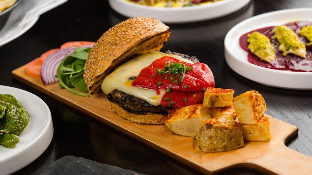 Hamburguesa Iberica · Grilled angus beef burger, melted Arzúa cheese, tomato confit, piquillo pepper, patatas bravas. (Contains dairy). *If you have any severe food allergies (I.E. Celiac disease), please contact the restaurant directly for further menu advisement.