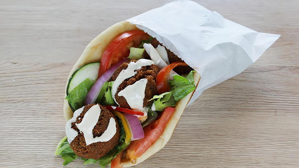 Falafels On A Pita  · Falafels on a pita with lettuce, tomato and onion with hummus spread