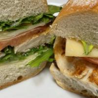 Chicken Paillard Sandwich · Rosemary marinade chicken is grilled and served on a baguette with arugula, tomato, thick sl...