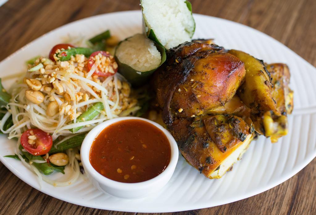 Gai Kamin Somtum · Grilled marinated half chicken, papaya salad, and coconut sticky rice. Served with chili-lime sauce.