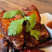 Thai-Herbed Wings · Golden-fried chicken wings topped with crispy Thai herbs. Served with sweet chili sauce.
