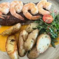Surf & Turf · Grilled skirt steak and shrimp, with sautéed  potatoes in aji amarillo aioli sauce and arugu...