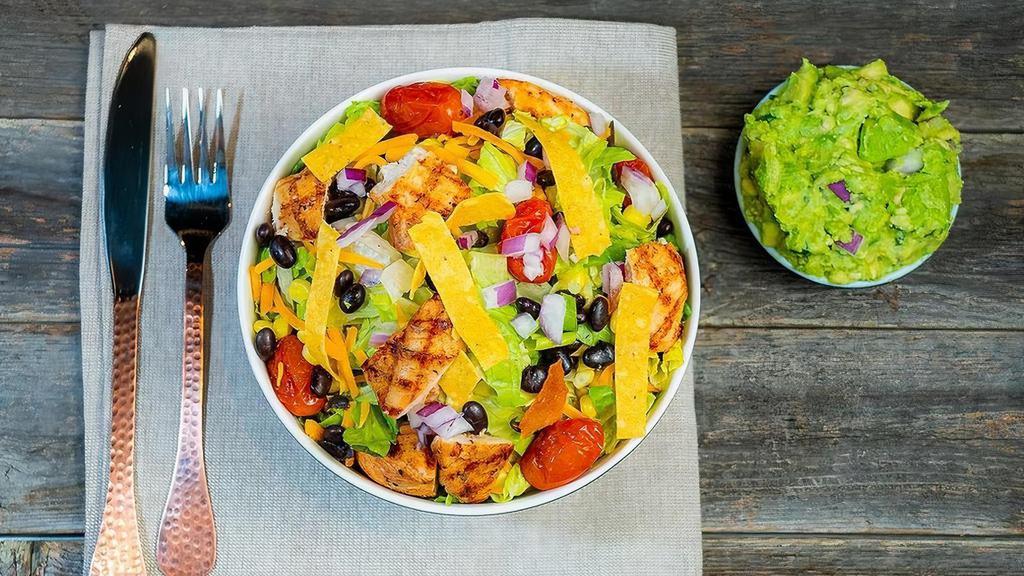 Mexican Mamba · romaine lettuce, tomato, grilled chicken, black beans, pico de gallo, cheddar cheese and corn topped with guacamole, tortilla chips and served with an avocado dressing