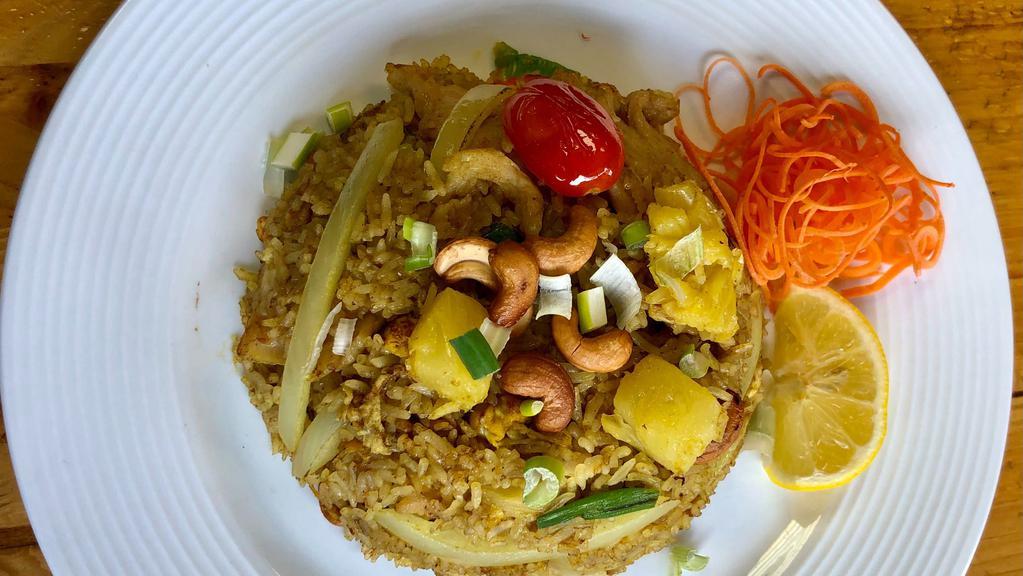 Pineapple Fried Rice · Stir-fried jasmine rice with pineapple, egg, onion, carrot, tomato, and cashew nuts flavored with curry powder and a variety of sauces.