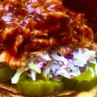 Pulled Pork Sandwich · Pulled Pork piled high on a brioche bun, creamy coleslaw, bbq sauce and sweet pickles.