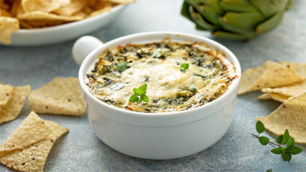 Artichoke Dip · Spinach, Parmesan, and feta dip, served with spiced pita chips.