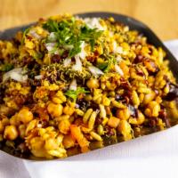 Bhel Poori · Vegan. Mix of puffed rice, onion, tomato, potato, mint and tamarind chutneys.