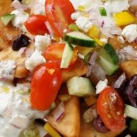 Greek Nachos · Fried Pita chips, feta-yogurt creme topped with chopped cucumbers, kalamata olives, grape to...