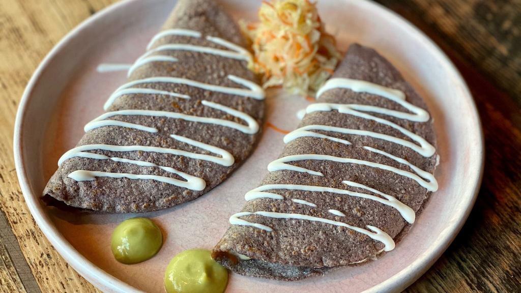 Steak Quesadillas · Order of two: Handmade organic blue corn tortillas with grass fed marinated grilled skirt steak, and oaxaca cheese. Topped with avocado salsa and crema fresca. Pickled cabbage on the side.