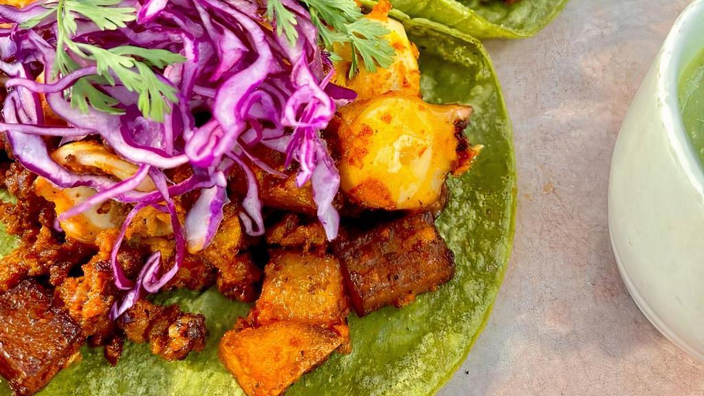 Tacos De Pulpo Y Chorizo · Sauteed octopus with Mexican chorizo and potatoes on a special green cactus corn tortilla, topped w/ red cabbage & cilantro and avocado salsa.