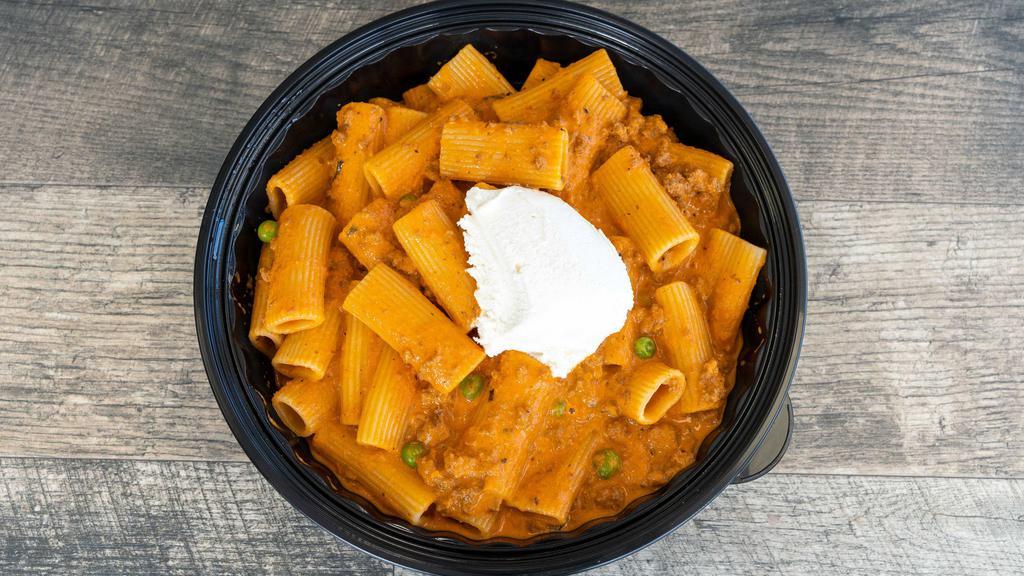 Pasta Alla Bolognese · Fresh ground beef and peas with tomato sauce and a touch of heavy cream topped with ricotta cheese.