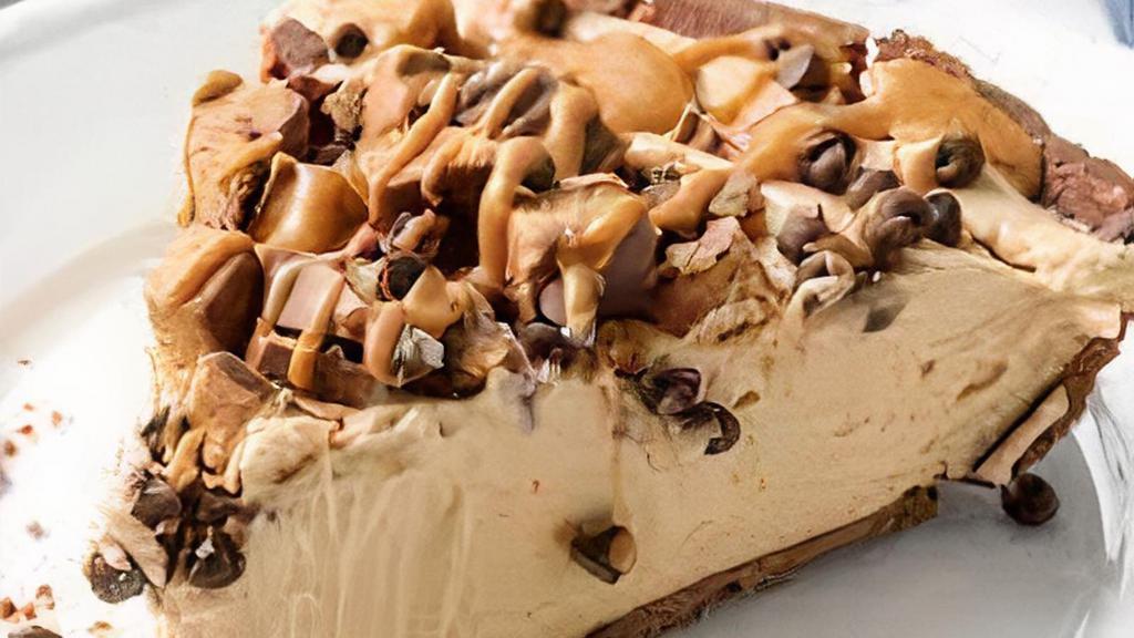 High Peanut Butter Pie · Creamy peanut butter mousse and silky milk chocolate fill chocolate cookie crust and are topped with chocolate, caramel, Reese's Peanut Butter Cups