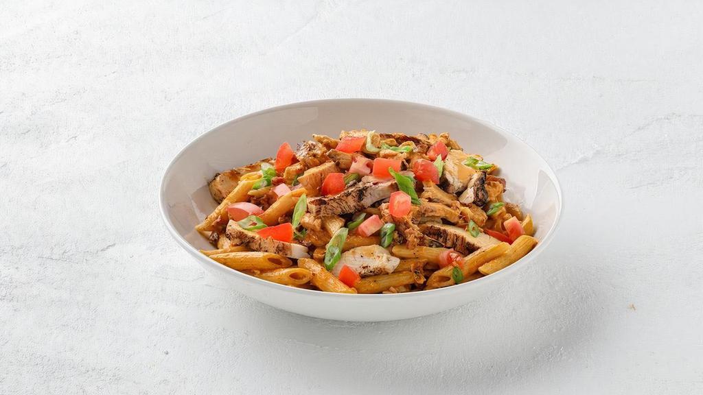 Cajun Chicken Penne  · Grilled chicken tossed with penne pasta, Applewood-smoked bacon and Chile-Asiago cream sauce, topped with diced tomatoes and chopped green onions.