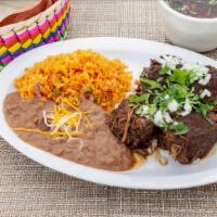 Birria / Birria Dinner · Birria servido con consome, arroz Mexicano y frijoles refritos, con una guarnición de lechug...