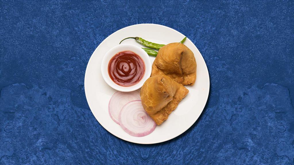 Indian Veggie Empanada (2 Pcs) · Crispy fried turnover with an amazing filling of spiced potatoes and green peas served with chutney.