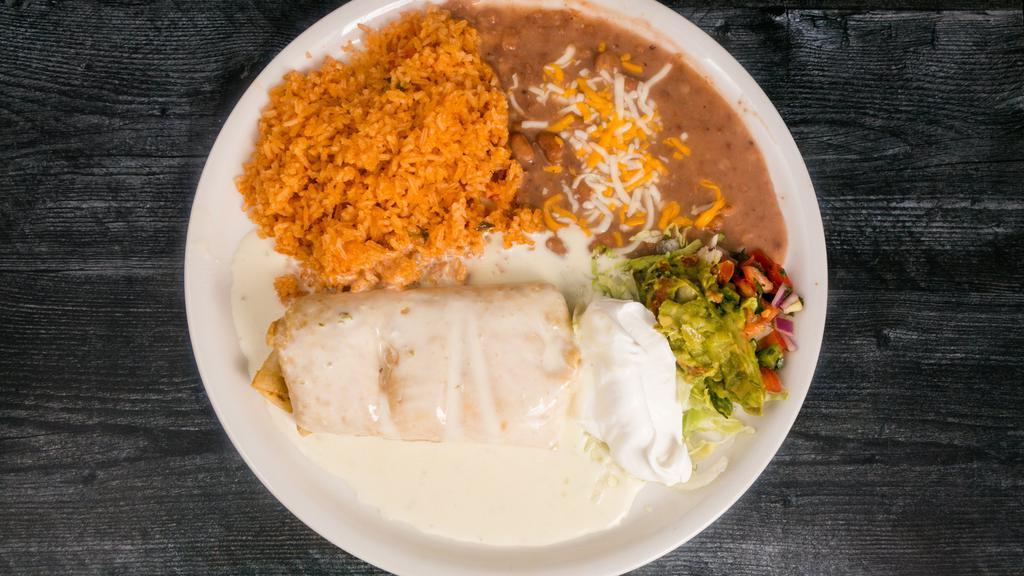 Chimichanga El Paso · Choice of chicken, ground beef or shredded beef stuffed in a large flour tortilla, fried to a golden crisp and topped with our creamy cheese sauce. Served with beans and rice garnished with lettuce, sour cream, tomatoes and guacamole.