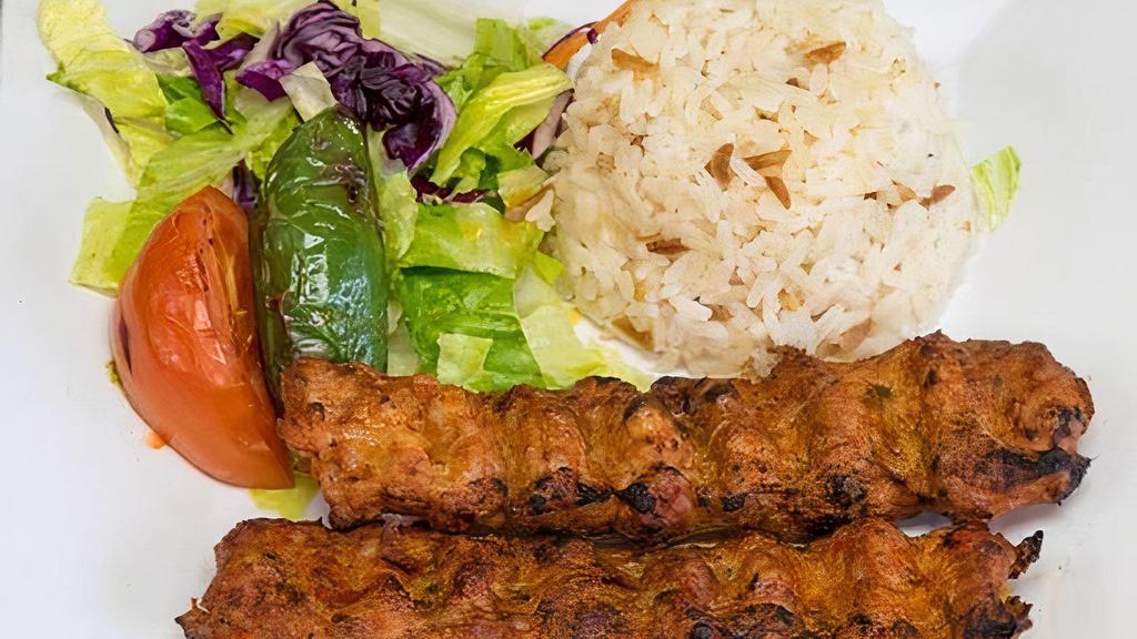 Chicken Adana · Ground chicken seasoned with spice and red peppers, gently spiced with paprika and grilled on skewers. Served with rice and salad.