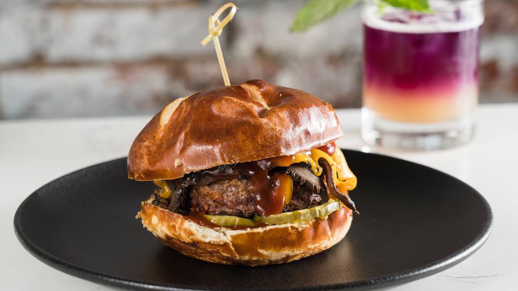 Smokey Bbq Burger · Beyond burger patty, BBQ Portobello, caramelized onion, American cheese, and pickle on a pretzel bun.