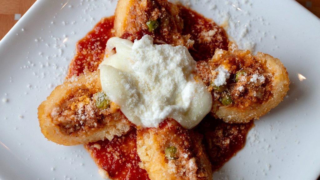  Parmesan Rice Ball · Homemade Rice balls with peas and ground beef layered with mozzarella and smothered in your favorite marinara sauce topped off with ricotta.