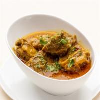 Goat Curry · Marinated goat with yogurt, onions, spices, simmered on a slow flame.