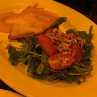 Grilled Salmon · Served with arugula, cherry tomatoes and shaved almonds in our lemon dressing and light spic...