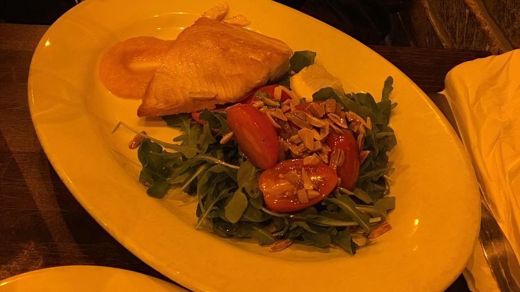 Grilled Salmon · Served with arugula, cherry tomatoes and shaved almonds in our lemon dressing and light spicy butternut squash cream.