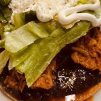 Tostada  Any Meat  · Fried corn tortilla, black beans spread, shredded lettuce, Mexican cream and cotija cheese.