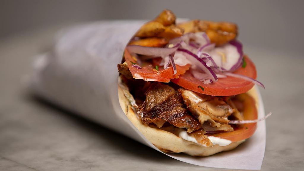 Gyro Pita Sandwich · Gyro sandwich with red onions, chopped tomatoes, dill, parsley and fries with tzatziki sauce.