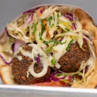 Falafel Sandwich · Fried chickpeas with fresh herb and spices. Agean slaw, tomatoes, and tahini dressing.