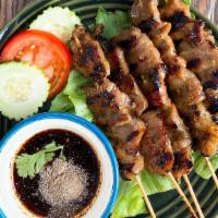 Moo Ping / หมูปิ้ง · Grilled marinated pork on a stick served with spicy homemade sauce.