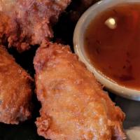 Thai Chicken Wings  / ปีกไก่ทอด · Fried chicken wings served with chili sauce.