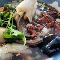 Kuai Chap / ก๋วยจั๊บ · Pork broth with rolled-up rice noodle sheets, pork intestine, pork liver, boiled egg, scalli...