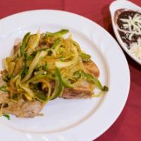 Chuletas Rancheras · Pork chops, sautéed onions, jalapeños, served with white rice and black beans.