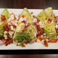 Wedge Salad · Iceberg lettuce with chunky blue cheese crumbles, crispy bacon, red onions and diced tomatoe...
