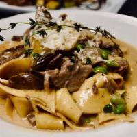 Homemade Pappardelle · Braised lamb short ribs, porcini mushrooms, and green peas in a light truffle cream sauce.