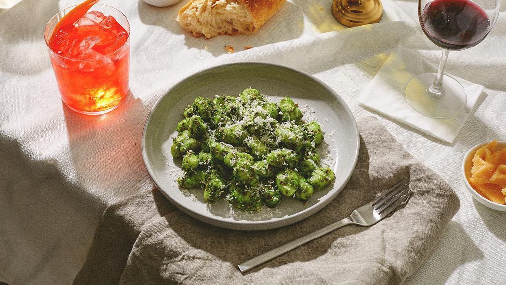 Gnocchi Pesto · Fluffy gnocchi tossed in a savory pesto sauce and topped with fresh Parmesan cheese.