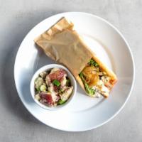 Greek Chicken Pita · Grilled chicken wrapped in a pita with Tzatziki, caramelized onions, feta, spring mix, and t...