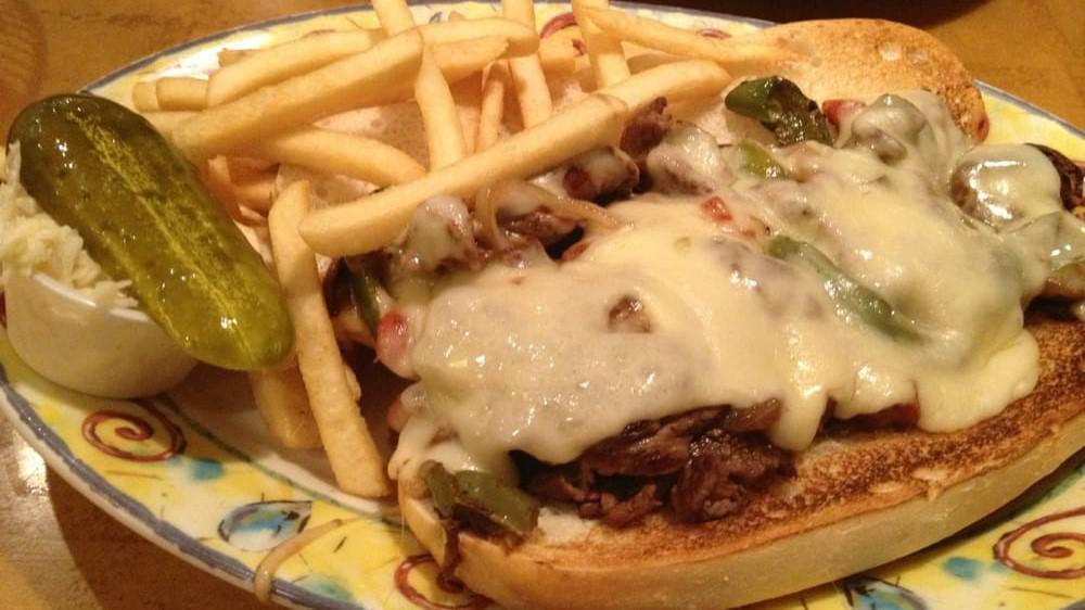 Philly Cheese Steak · Grilled sliced steak served on a baguette, topped with sautéed onions, peppers and cheddar cheese. Diner classic.