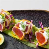 Yellow Fin Tuna Tostadas · Avocado salsa, pickled cabbage, herbed cream, and salmon roe.
