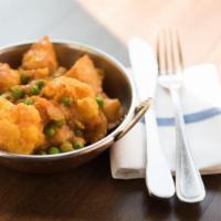 Aloo Gobi Mutter · Lightly spiced potatoes, cauliflower & green peas cooked in ginger & tomato sauce.