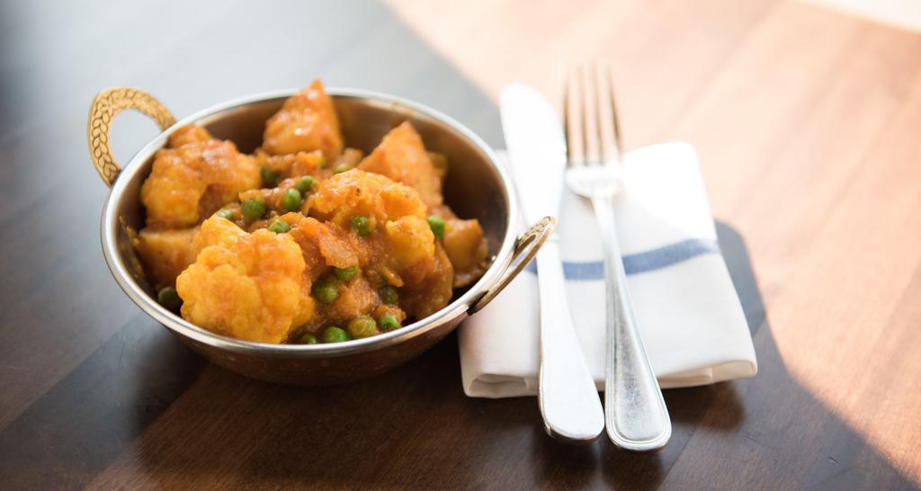 Aloo Gobi Mutter · Lightly spiced potatoes, cauliflower & green peas cooked in ginger & tomato sauce.