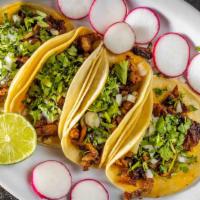 Taco Al Pastor · Our own creation. Marinated pork topped with onions and cilantro.