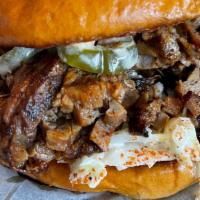 The Brisket · House smoked brisket with southern slaw, pickled jalapeños and comeback sauce on a toasted b...