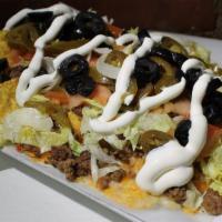 The Grill Nachos · House made Tortilla Chips topped with Kawan's Chili, melted Cheese, Lettuce, Jalapeños & Pic...