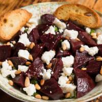 Roasted Beets · Roasted with fresh herbs and garlic, topped with pine nuts and goat cheese.
